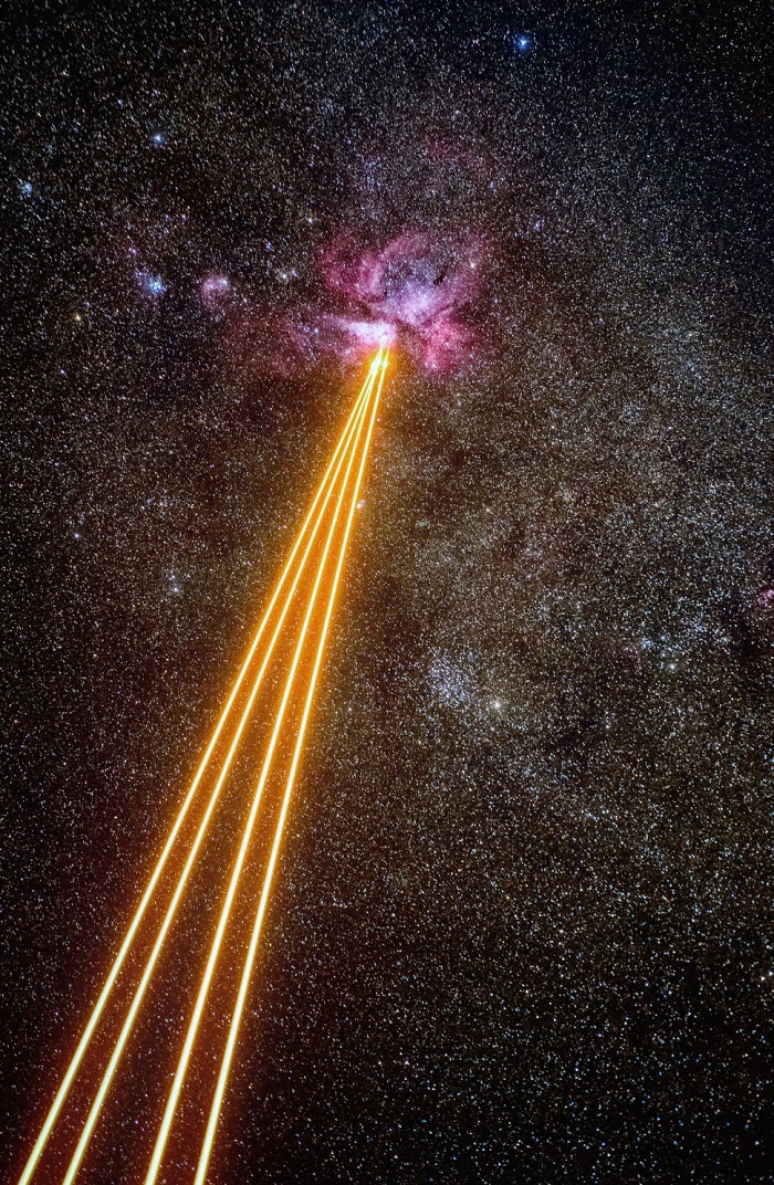 Четири оранжеви лазерни лъча пламтят през Млечния път докато ядосана