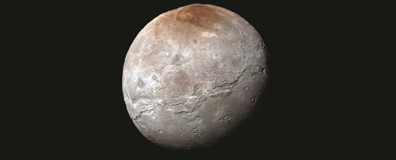 Спътникът на Плутон Харон има интересна червена шапчица на един
